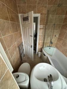 een badkamer met een wastafel, een toilet en een bad bij 30 min STN or to central London in Enfield Lock
