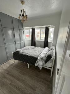Schlafzimmer mit einem Bett, einem Fenster und einem Kronleuchter in der Unterkunft 30 min STN or to central London in Enfield Lock