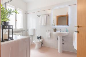 a white bathroom with a sink and a toilet at Palazzo Spada - Appartamento Cigno con 2 camere da letto in Codigoro +17 photos