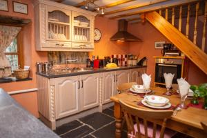 a kitchen with a wooden table and a sink at Y Cartws Llanwenog in Llanwenog