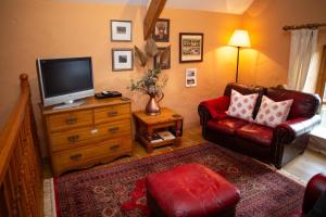a living room with a couch and a television at Y Cartws Llanwenog in Llanwenog