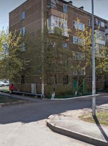 ein großes Backsteingebäude am Straßenrand in der Unterkunft Квартира между правым и левым берегом, рядом с набережной на улице Габдуллина in Astana