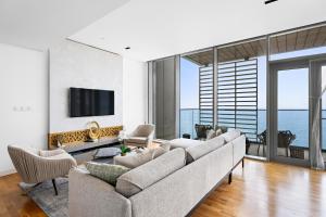 a living room with a couch and a tv at New 2 bedroom in Bluewaters with Direct Sea View in Dubai