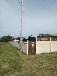 a fence in a field with a sign on it at Las Mozitas 1 in Barra del Chuy