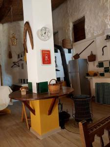 una habitación con una mesa y un reloj en la pared en La casita del Horno, en Pedralba