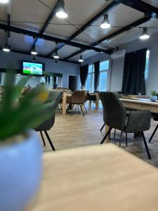 a meeting room with tables and chairs and a tv at XXL rooms&spa in Osijek