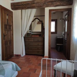 una camera da letto con cassettiera, specchio e lavandino di Canteo a Chavida