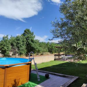 una piscina in un cortile con recinzione e alberi di Canteo a Chavida