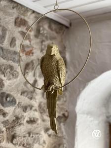 um pássaro empoleirado num bambolê numa parede em L’Oiseau Doré em Bram