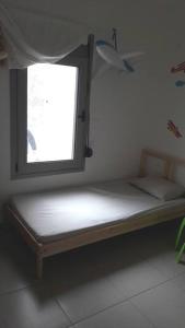 een klein bed in een kamer met een raam bij Anesis with yard in Myrtos