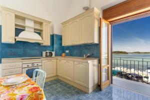 cocina con mesa y vistas al océano en Isola Dei Conigli by BarbarHouse, en Porto Cesareo