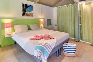 une chambre avec un grand lit avec des serviettes dessus dans l'établissement Belambra Clubs Seignosse Les Estagnots, à Seignosse