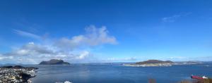 une grande étendue d'eau avec des îles au loin dans l'établissement Ytterland Apartments, à Ålesund