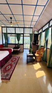 a bedroom with a bed and a couch and a table at Coorg Heritage Hill View Resort in Madikeri