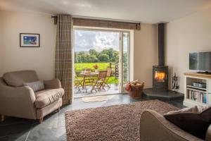 a living room with a fireplace and a sliding glass door at Y Cartws Eglwyswrw in Eglwyswrw