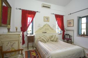 Schlafzimmer mit einem großen Bett und roten Vorhängen in der Unterkunft Dar Chennoufi in Sicca Veneria