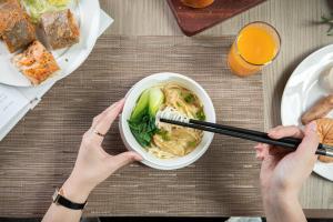 Due persone che mangiano una ciotola di zuppa di noodle con le bacchette. di Hilton Shenzhen World Exhibition & Convention Center a Shenzhen