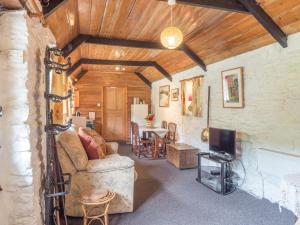 a living room with a couch and a table at Rhyd y Brown Cottage Llys Y Fran in Pen-ffordd