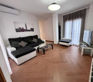 a living room with a black and white couch at APARTAMENTOS TURíSTICOS MONTASOL 1 in Montánchez