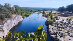 a river with people swimming in the water at Au Mazet du Parc in Lédenon