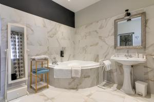 a bathroom with a tub and a sink at Hôtel Henri IV in Tarbes