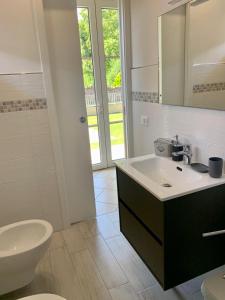 a bathroom with a sink and a toilet and a mirror at Elicriso in Barga +25 photos
