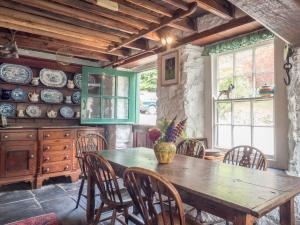 a dining room with a wooden table and chairs at Rhyd y Brown Farmhouse Llys Y Fran in Pen-ffordd