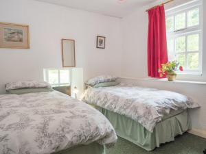 a bedroom with two beds and a window at Rhyd y Brown Farmhouse Llys Y Fran in Pen-ffordd