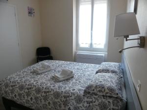 a bedroom with a bed with two towels on it at Appartement F2 Le Puy-de-Dôme in Châtel-Guyon