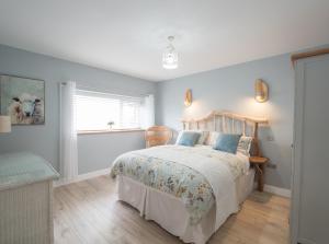 a bedroom with a bed and a window at White Fields Cottage Carmarthen in Carmarthen
