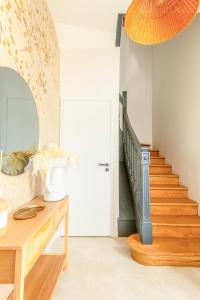 a hallway with a wooden table and a staircase at Villa Marie climatisation piscine & jardin Dijon centre in Dijon