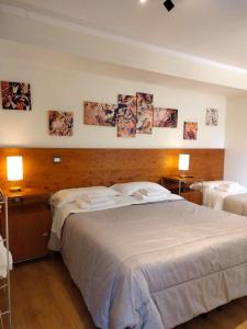 拉奎拉的住宿－Camaga，一间卧室设有两张床和两张带台灯的桌子。