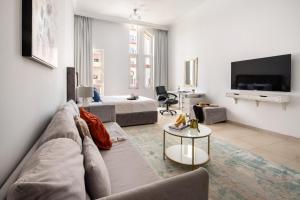 a living room with a couch and a tv at Frank Porter - Canal Residence in Dubai