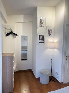 a white room with a lamp and pictures on the wall at Appartamento Turistico Scilla da Franca in Scilla
