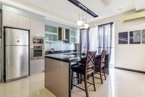 a kitchen with a island with chairs and a refrigerator at Duplex Condominium In Bukit Bintang For Rent in Kuala Lumpur