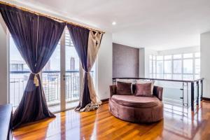 a living room with a chair and a large window at Duplex Condominium In Bukit Bintang For Rent in Kuala Lumpur