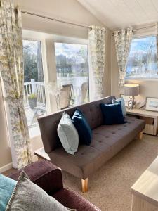 a living room with a brown couch with blue pillows at Haggerston Lola the Lodge and Betty the Van in Cheswick