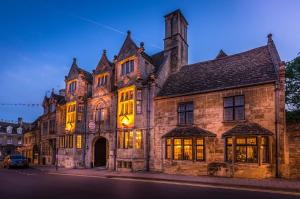 an old stone building with its lights on at The Talbot Hotel, Oundle , Near Peterborough in Oundle