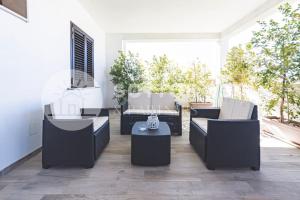 a patio with couches and a table on a porch at Infiore Apartment in Leverano