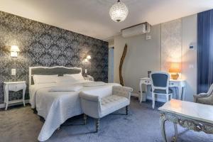 a bedroom with a large bed and a chair at Hôtel Henri IV in Tarbes
