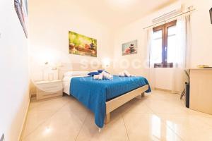 a white bedroom with a bed and a window at Infiore Apartment in Leverano