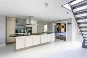 una cucina con mobili bianchi e una scala di Cable Cottage a Salcombe