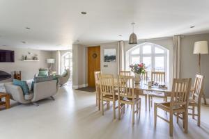 una sala da pranzo e un soggiorno con tavolo e sedie di Cable Cottage a Salcombe