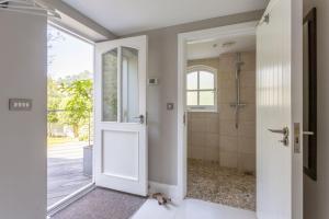una porta aperta che conduce a un bagno con doccia di Cable Cottage a Salcombe Altre 22 foto
