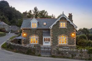 una grande casa in pietra con luci gialle di Cable Cottage a Salcombe
