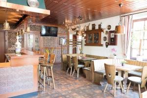 un restaurant avec un bar, des tables et des chaises dans l'établissement Gasthof Isernhagen, à Gödenstorf