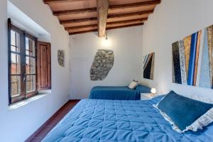 a bedroom with a blue bed and a window at Antica Dimora di Laura in Barberino di Mugello