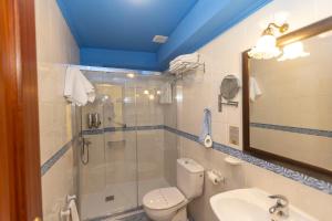 Un baño con ducha, inodoro y lavabo. en Escuder Apartamentos Turísticos, en Ribadeo 37 fotos más