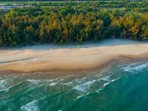 an aerial view of a beach with trees in the background at Ho Tram Beach Boutique Resort & Spa in Ho Tram