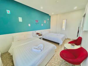 una habitación de hotel con 2 camas y una silla roja en Gia Khang, en Da Lat